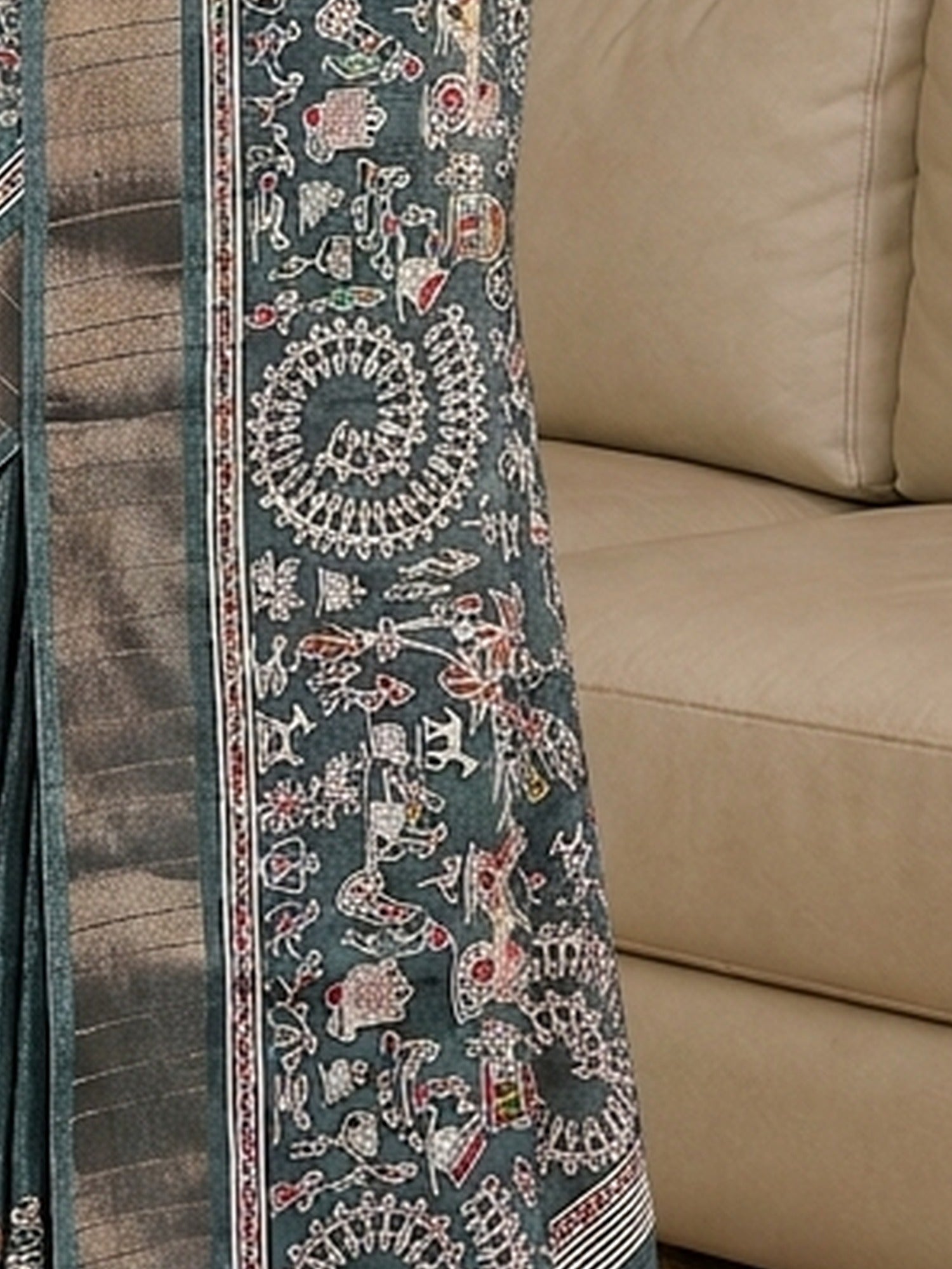 Pallu detail of teal green silk blend saree showing tribal folk-art motifs and zari border