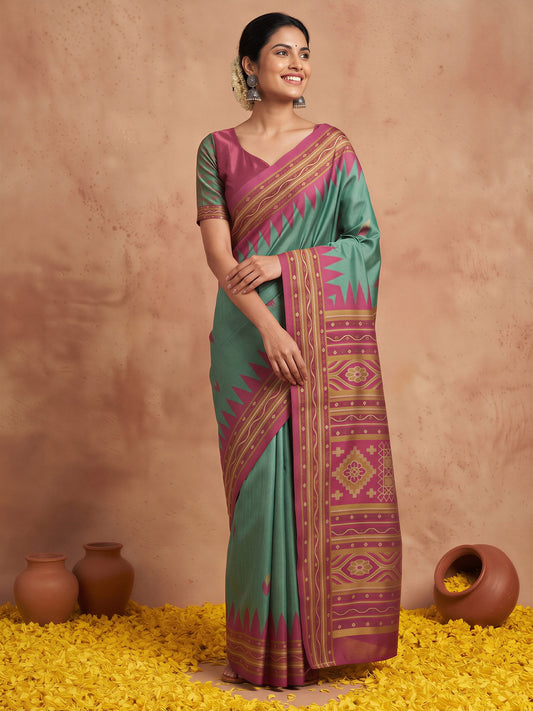 Woman wearing teal green silk blend saree with ikat resist-dyed pattern and magenta blouse