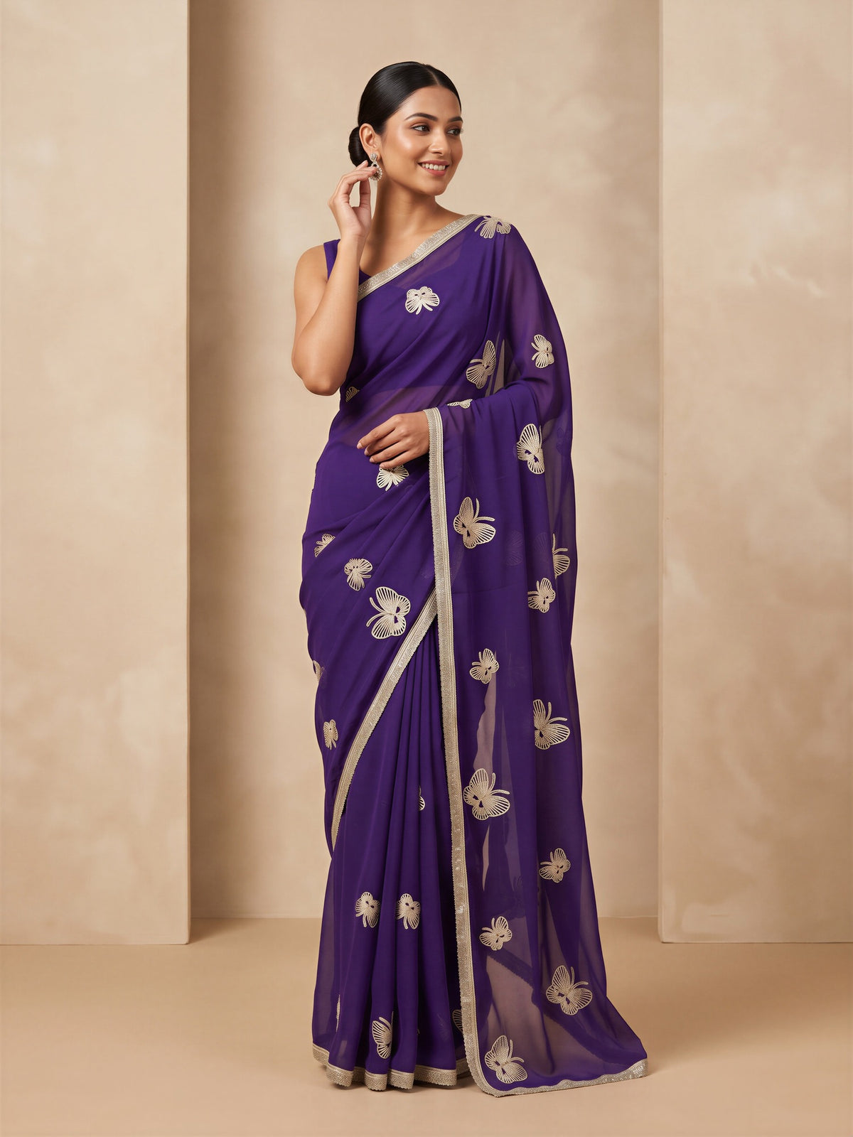 Woman wearing purple georgette saree with embroidered motif work and purple blouse