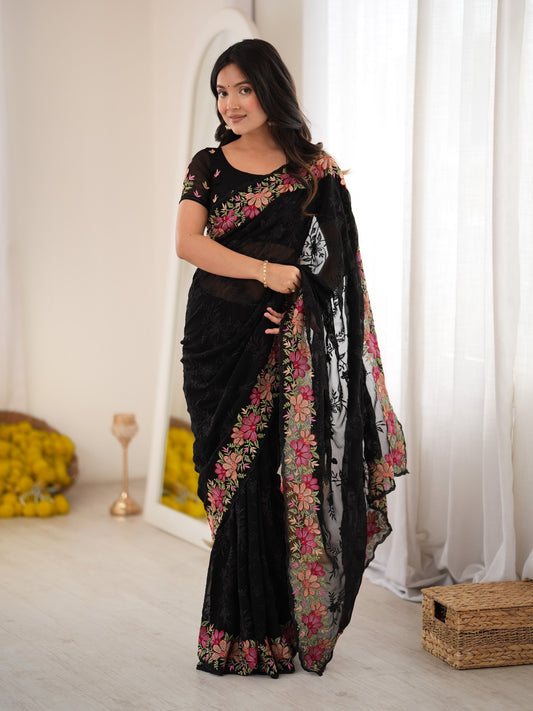 Woman wearing black georgette saree with all-over floral design and black blouse