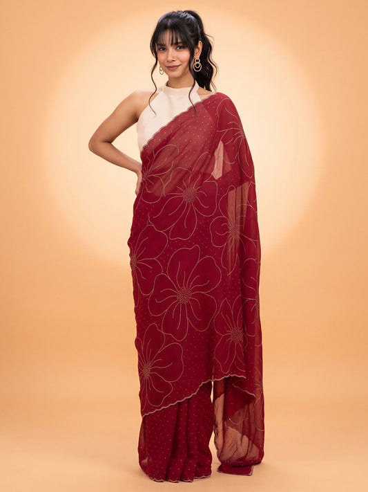 Woman wearing pink satin silk saree with ornamented surface design and white blouse