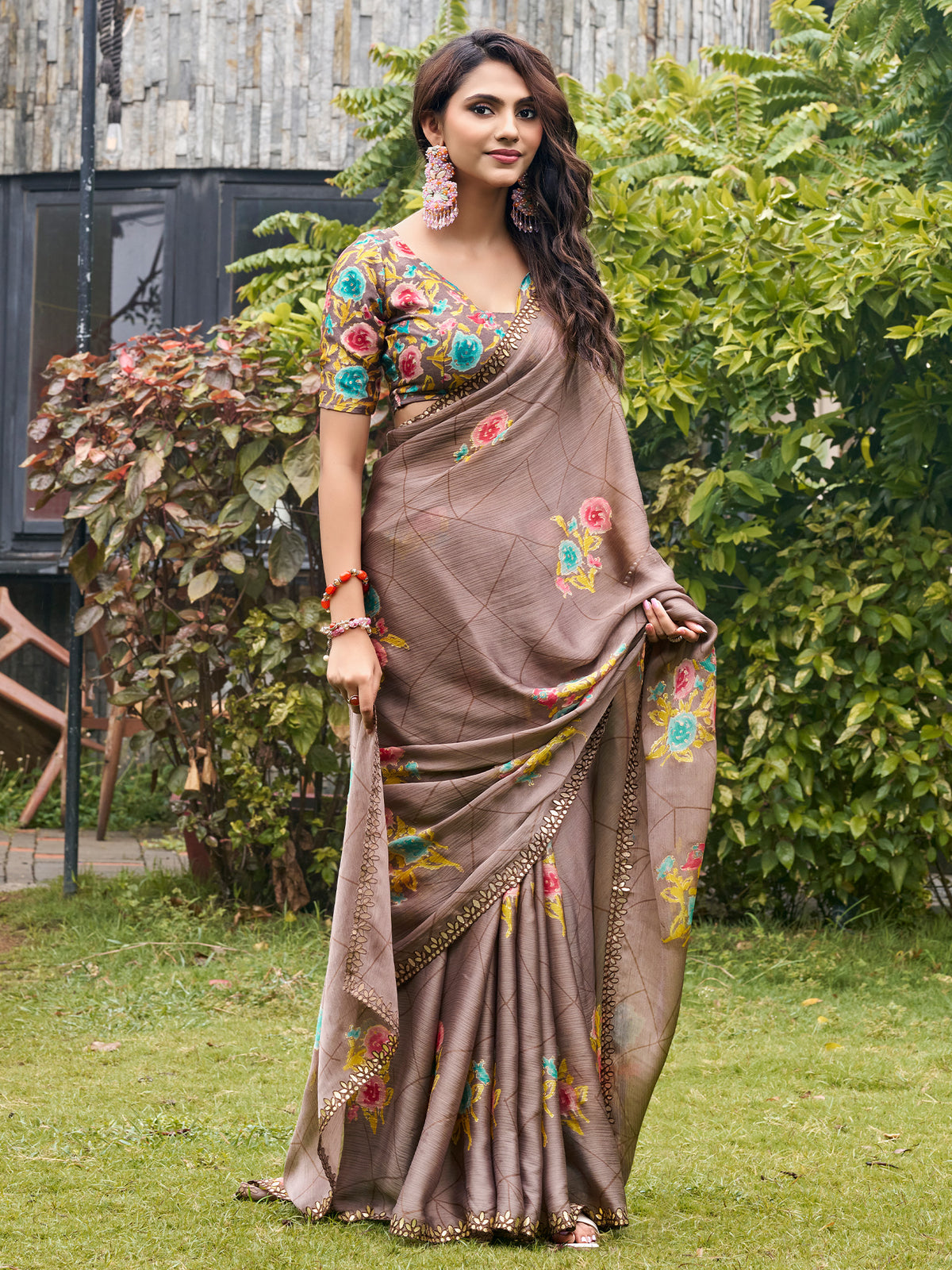 Woman wearing light brown chiffon saree with metallic foil print work and multicolored blouse