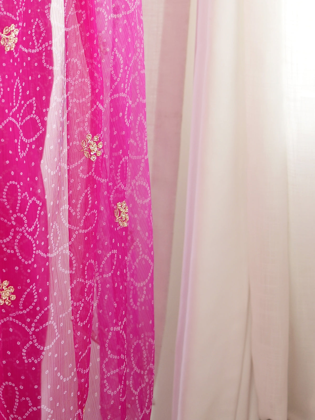 Pallu detail of pink georgette saree showing bandhani tie-dye dot work and embellished border