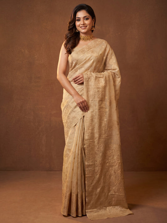Woman wearing cream silk blend saree with zari butta (metallic motif) work and cream blouse