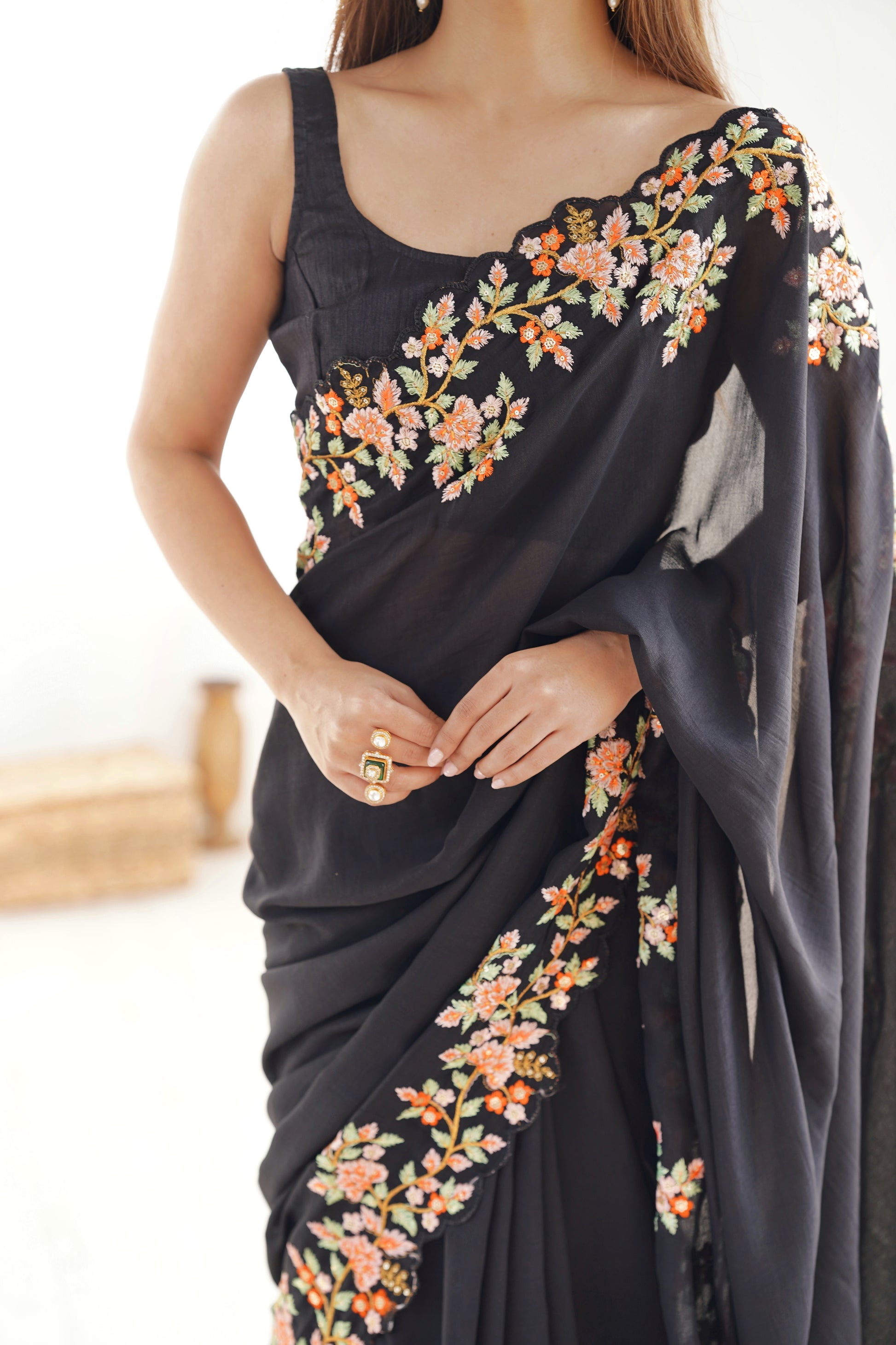Black saree with floral embroidery held by a person