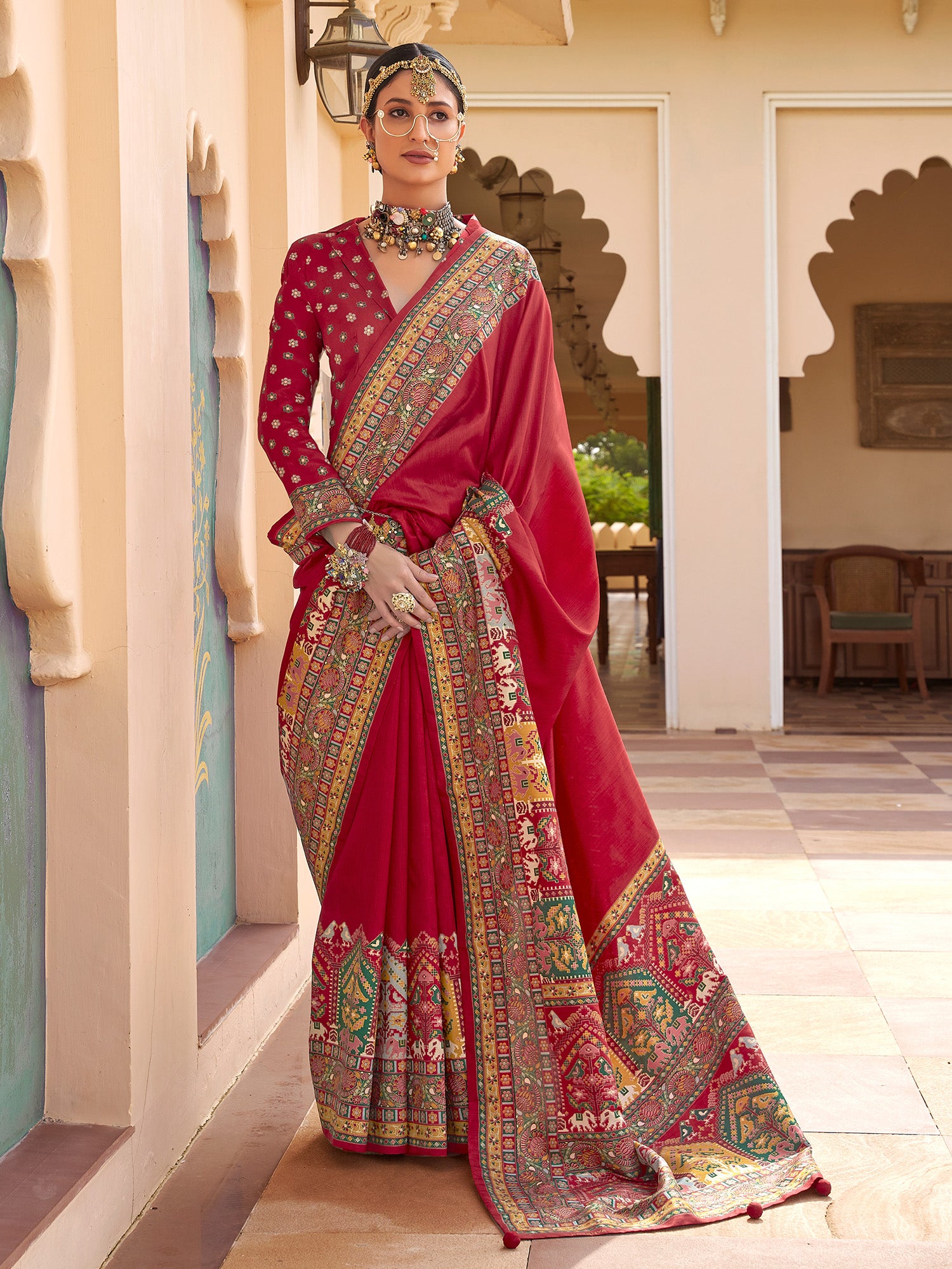 Crimson red Patola silk saree with elephant and floral motifs, multicolor Patola border and tassels