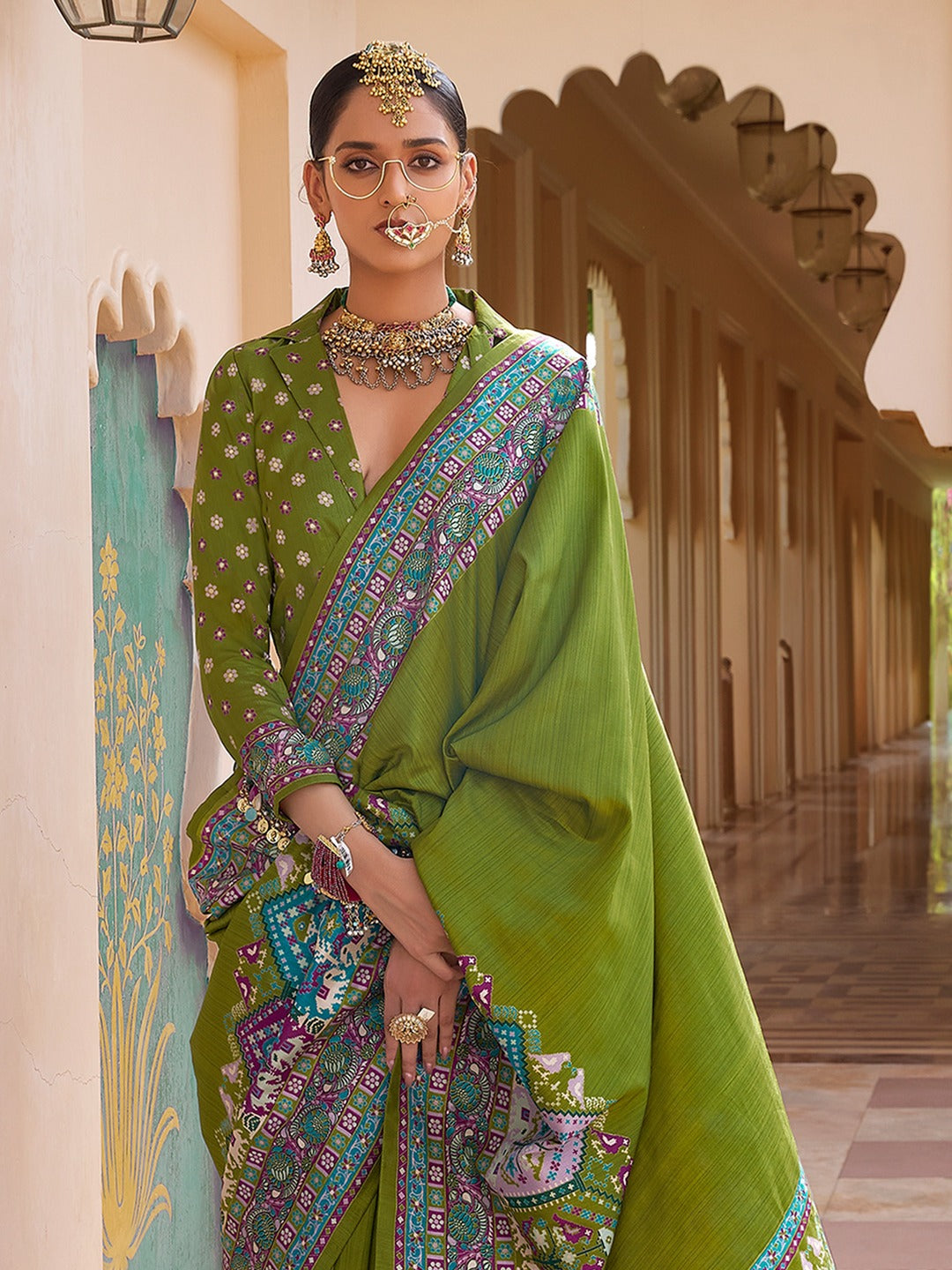 Olive green Patola silk saree with elephant and floral motifs, multicolor Patola border and tassels