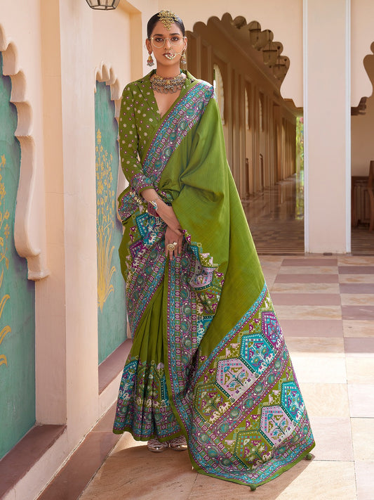 Olive green Patola silk saree with elephant and floral motifs, multicolor Patola border and tassels