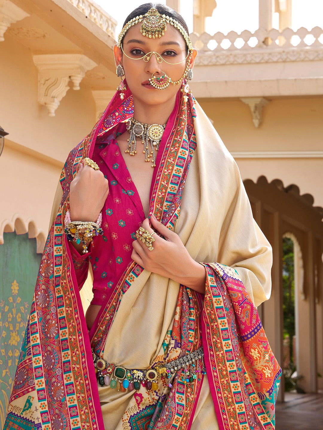 Ivory Patola silk saree with elephant and floral motifs, multicolor Patola border and tassels, worn by model