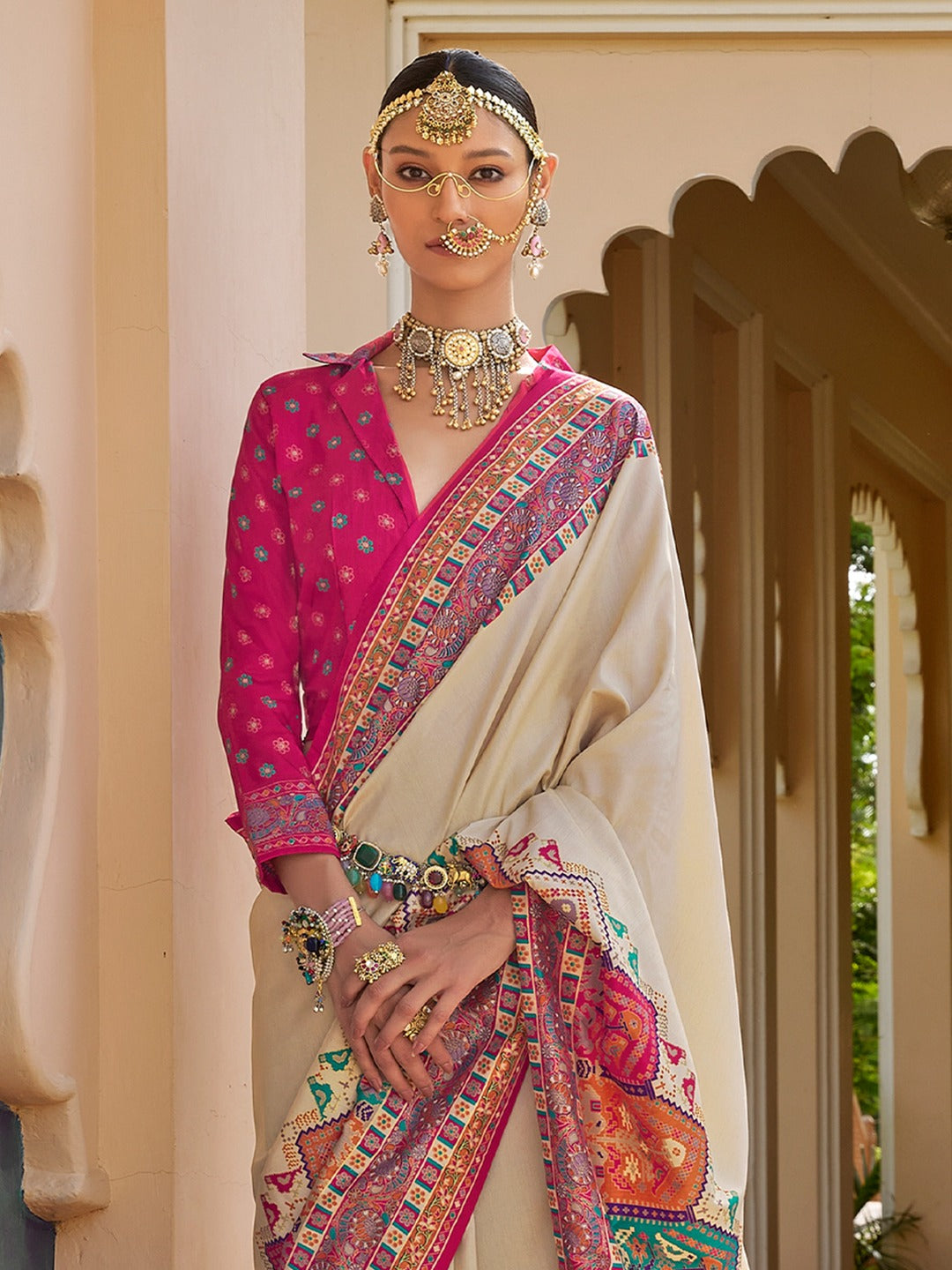 Ivory Patola silk saree with elephant and floral motifs, multicolor Patola border and tassels, worn by model