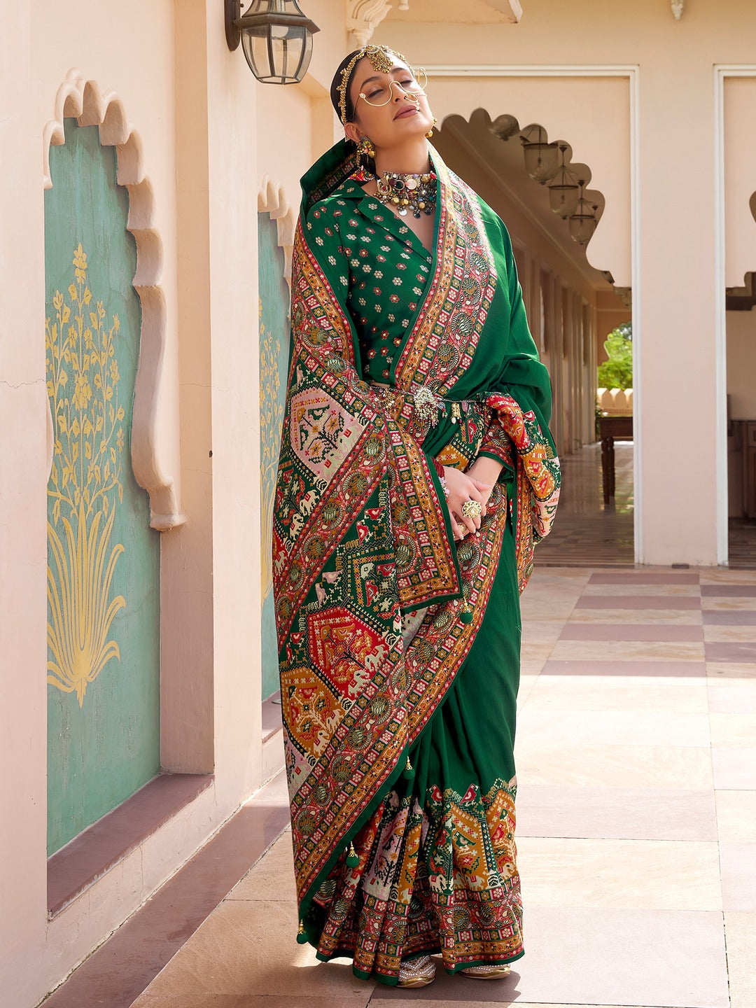 merald green Patola silk saree with elephant and floral motifs, multicolor Patola border, zari butta work and tassels, worn by model with full-sleeve matching blouse