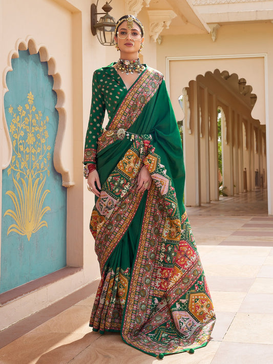 merald green Patola silk saree with elephant and floral motifs, multicolor Patola border, zari butta work and tassels, worn by model with full-sleeve matching blouse